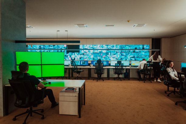 在数据系统控制室工作的男性保安员办公室技术人员在多台显示器工作站工作，保安人员在多台显示器上工作男性计算机操作图片下载