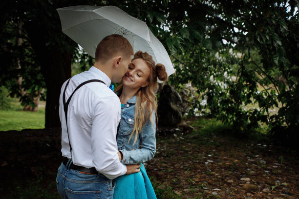 相爱的小情侣在雨中撑着伞图片下载