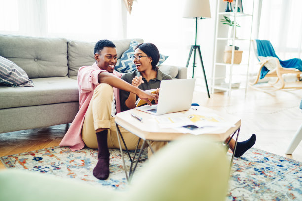 繁荣的自由职业婚姻享受远程工作在一起在家庭公寓的工作过程中笑着有趣的笑话，幸福的黑皮肤情侣在使用笔记本电脑时高兴图片下载