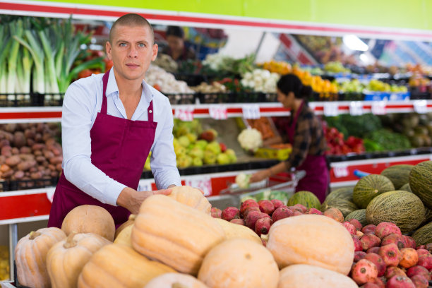 小贩在杂货店的货架上摆放水果和蔬菜图片下载