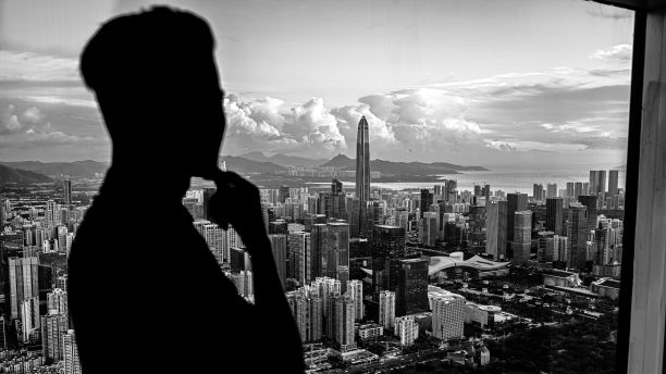 一个人透过窗户看深圳的轮廓的灰度镜头。图片下载