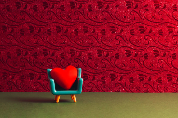 创意的七八十年代复古时尚美学的爱的概念。极简浪漫的想法。红心型枕头放在绿松石扶手椅上，复古的洋红色壁纸。图片下载