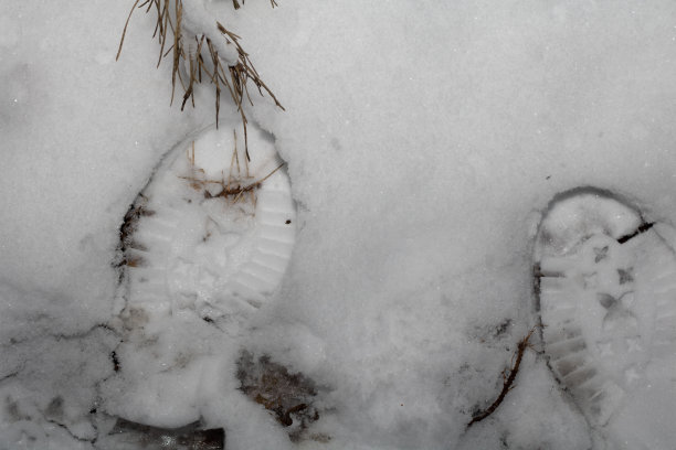 从鞋子上拍下雪地上的人类脚印图片下载