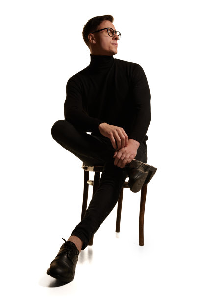 领袖。肖像时尚帅气的商人在总黑色服装坐在椅子上孤立的白色背景。美，时尚，风格和商业的概念图片下载