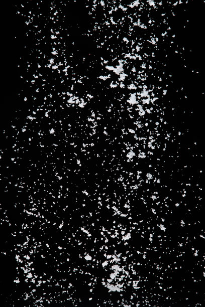 照片图像的雪花纷纷落下，大的大的小的大小的雪。冻结拍摄在黑色背景隔离覆盖。蓬松的白色雪花在半空中飞溅云。真雪高速快门图片下载