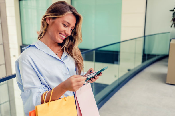 一名年轻女子用智能手机进行在线支付。一名女子用智能手机进行在线信用卡支付。图片下载