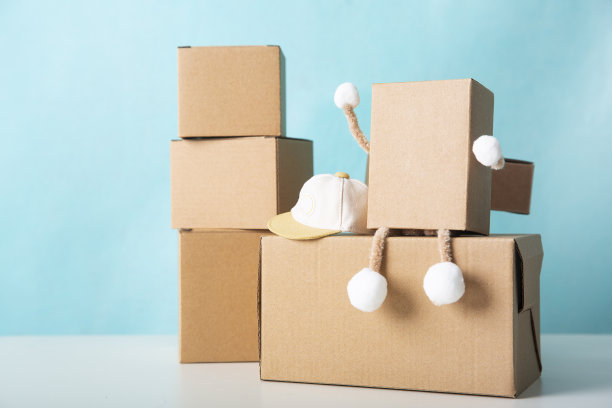 微型纸箱卡通模型，坐在纸箱热情的快递员图片下载