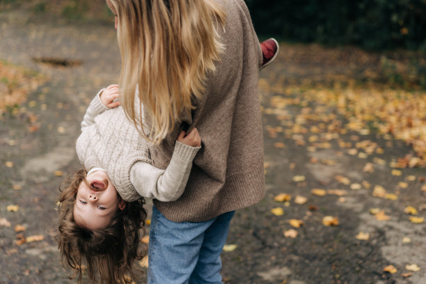 快乐的年轻妈妈和小女儿在外面玩耍。图片下载