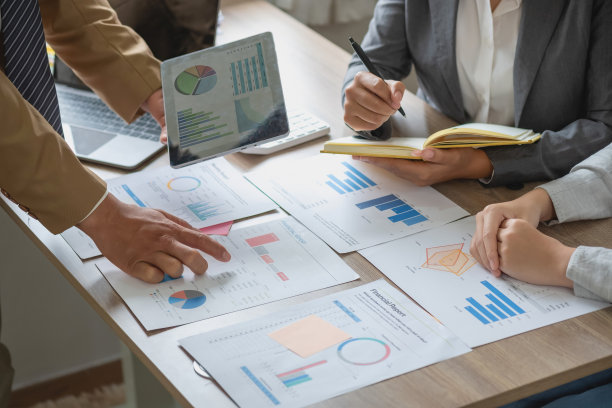 营销，财务，会计，计划，业务团队使用计算器和图形分析电脑笔记本电脑平板电脑来计划营销策略，并为公司进行有利可图的投资。图片下载
