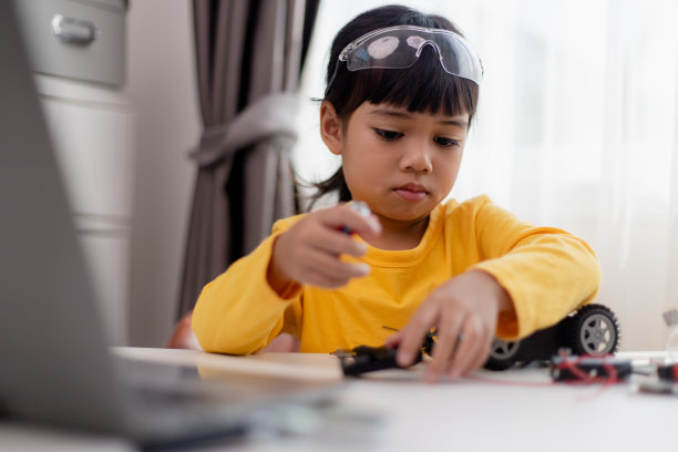 亚洲学生在家里学习在STEM、STEAM、数学、工程、科学和技术领域为儿童机器人概念编写计算机代码的机器人汽车和电子电路板电缆。图片下载