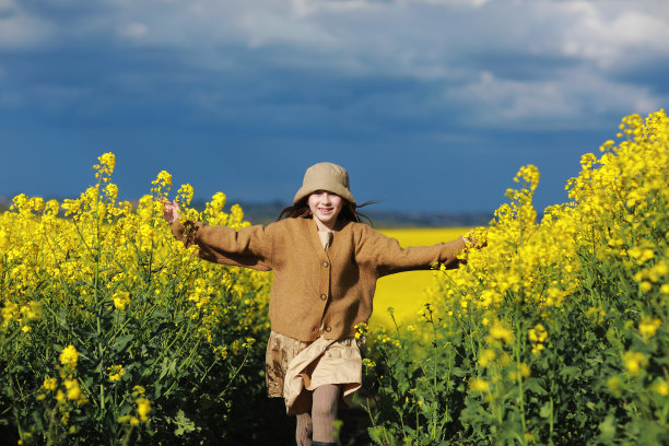 夏天，孩子们在大自然中玩耍和奔跑。可爱的小女孩在油菜地里。暑假的概念素材图片