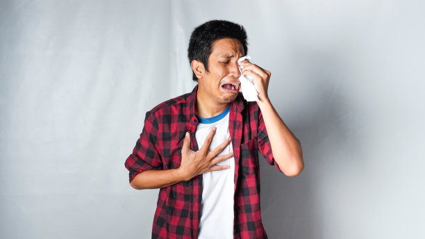 穿着红色法兰绒t恤的亚洲男子用纸巾隔离白色背景哭泣图片下载