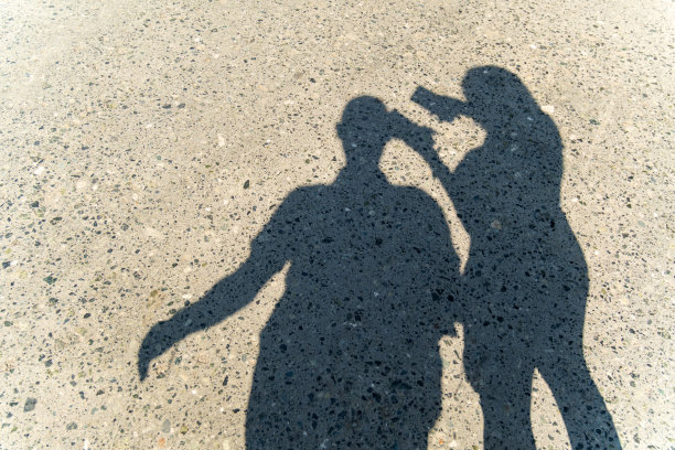 柏油路上两个人的影子是一男一女。阳光灿烂的日子，路边的柏油路图片下载