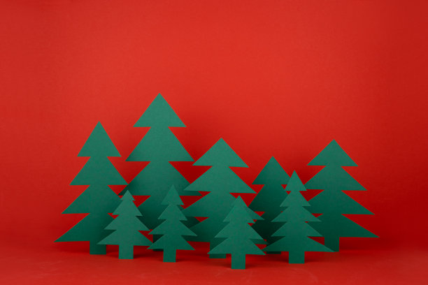 传统的圣诞节日背景与卡通纸云杉森林在优雅的婴儿风格的红色背景。新年模型为广告，设计，卡片，海报，传单。图片下载