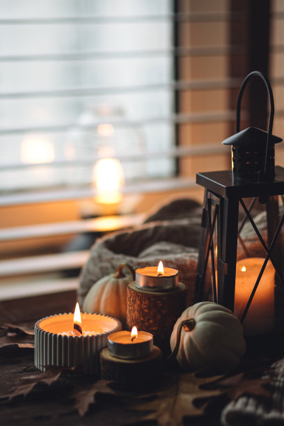 芬芳的蜡烛，南瓜，羊毛衫，树叶，肉桂组成舒适的秋天。在一个灰色的秋天的早晨，芳香疗法，舒适和放松的家庭气氛。木质背景特写。图片下载