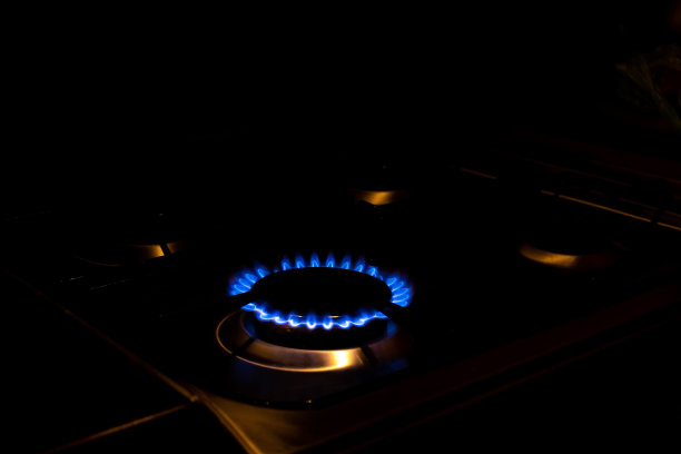 煤气炉起火。昂贵的天然气和能源资源的概念。家用现代煤气炉。晚上燃烧的燃烧器。图片下载