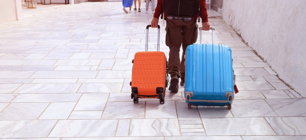 年轻的游客拿着行李走在人行横道上，在机场旅行图片下载