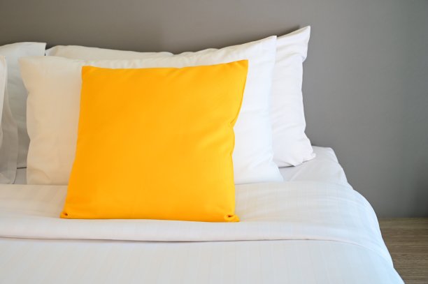 白色床上的黄色枕头，室内设计图片下载