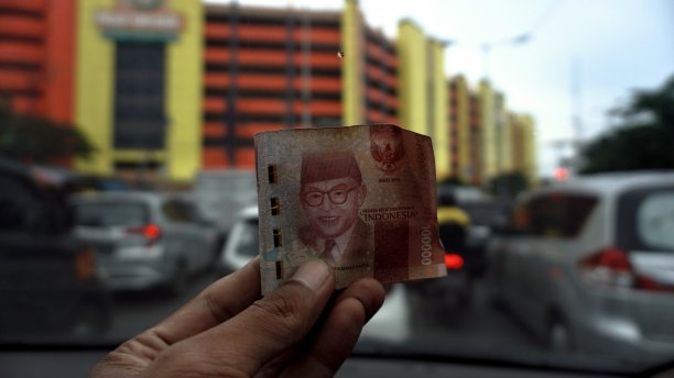 近距离的手在车里以印尼盾计价的钞票。卢比是印尼的货币图片下载