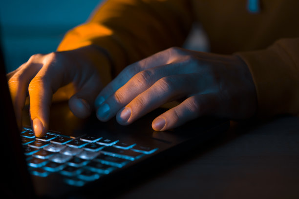 双手在笔记本电脑键盘上打字。图片下载