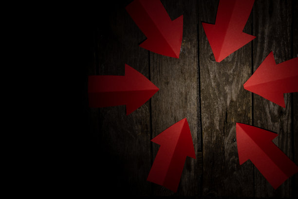 在深色背景上，红色纸箭头指向桌子的中心图片下载