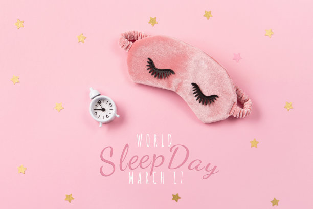 世界睡眠日定在3月。可爱的睡眠面具和闹钟在粉红色粉彩背景，俯视图。图片下载