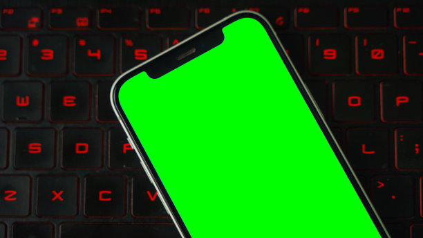 手机用空白的绿色屏幕平铺，智能手机隔离在笔记本电脑或桌面键盘背景上图片下载