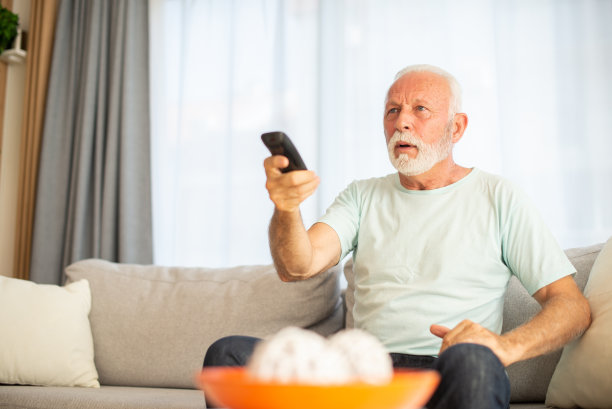 男人在家里享受她最喜欢的电视节目图片下载
