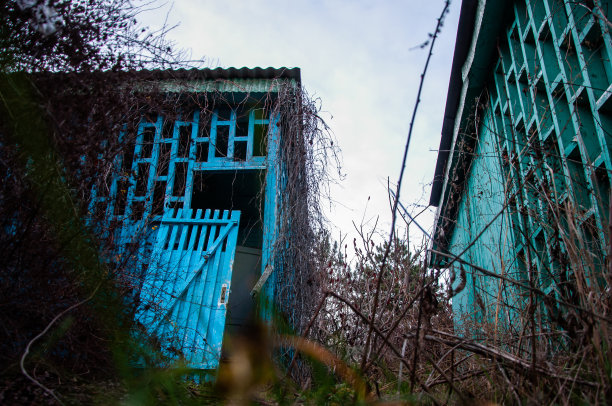 被遗弃的儿童营地。在灌木丛中，雪和绿色的木制避暑小屋。图片下载