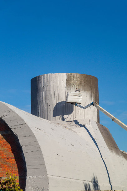 用白石灰覆盖建筑结构。粉刷混凝土管道。高空施工。图片下载
