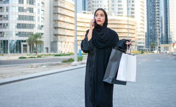 快乐的阿拉伯女性在街头购物图片下载