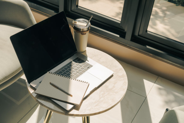 笔记本电脑和重复使用的杯子放在桌子上。图片下载