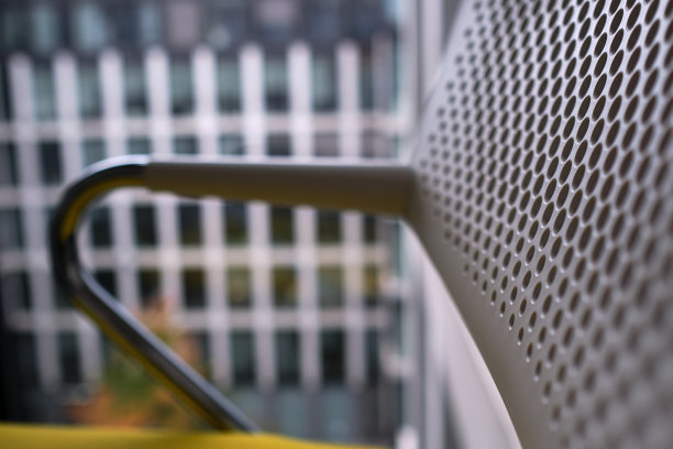 办公椅靠背和扶手的细节，背景是办公楼图片下载