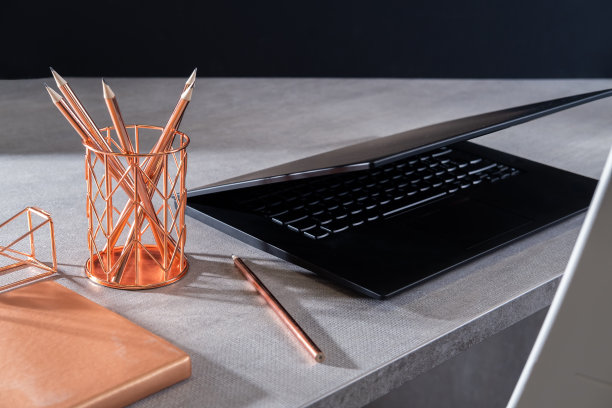 现代灰色办公室里的黑色笔记本电脑。图片下载