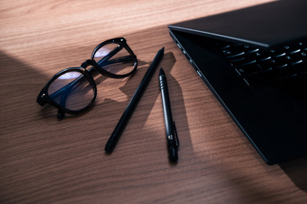 黑色笔记本电脑放在木桌上，特写。图片下载