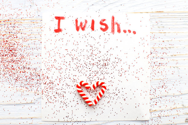 笔记本与愿望清单在复古木桌与拐杖糖。圣诞节计划概念。图片下载