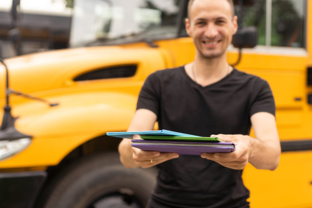 年轻教师的肖像在校车附近图片下载