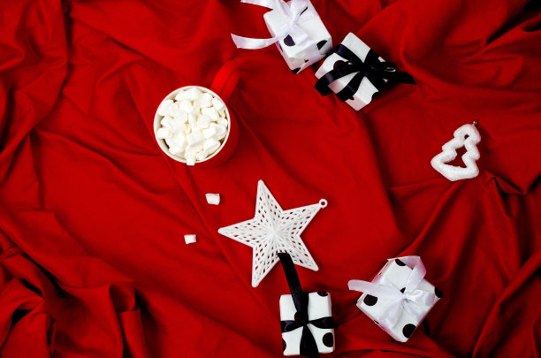 红色的杯子里有可可和棉花糖，放在红色的床上图片下载