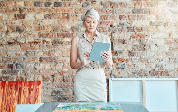 商业女性在平板电脑上规划，画廊经理或设计师在展览上工作，并在办公室的互联网上与有创意的人在线交流。企业家在博物馆拍卖绘画图片下载