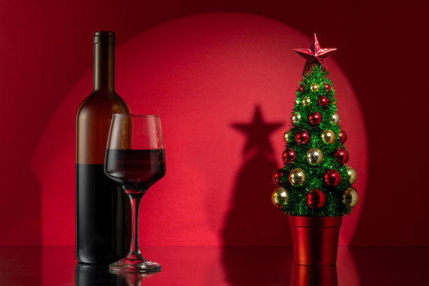 圣诞树，红色的酒瓶在红色的墙壁背景。新年或圣诞节的概念。图片下载