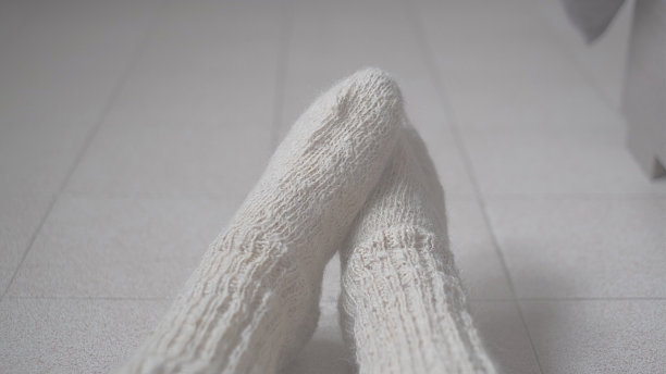女人在冬天移动的脚在羊毛白色袜子靠近图片下载