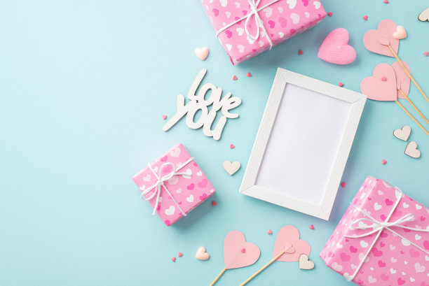 情人节的概念。顶部视图照片相框粉红色礼物盒纸心形木棍铭文爱你和洒在孤立的粉彩蓝色背景与空白图片下载