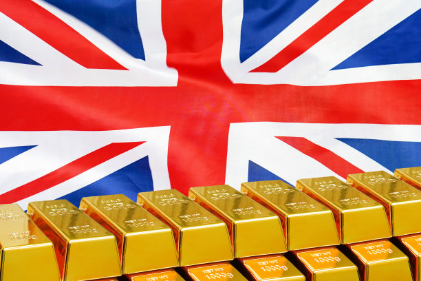 英国国旗背景上的一排金条：英国黄金储备和基金概念图片下载