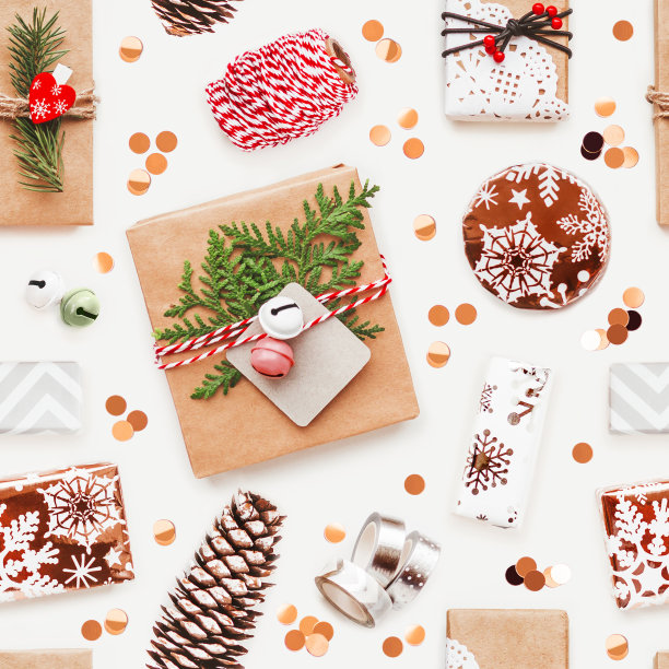 照片无缝图案与圣诞礼物和新年装饰品。顶部视图的礼盒在工艺和明亮的纸与彩色铃铛，线和松树树枝。图片下载
