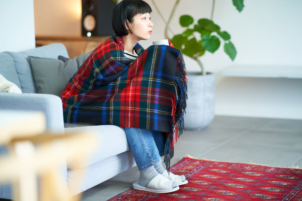一个裹着毯子拿着杯子的女人图片下载