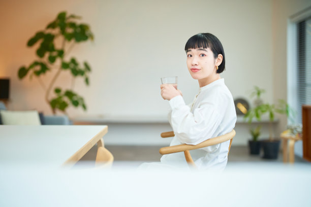 年轻女子在房间里喝水图片下载