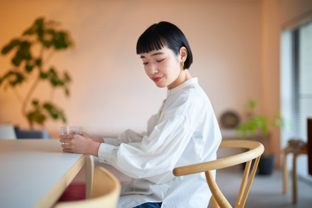 年轻女子在房间里喝水图片下载