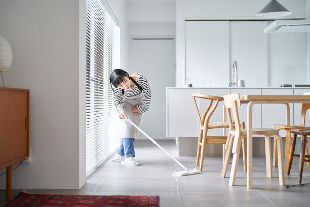 年轻女子在打扫房间的地板图片下载