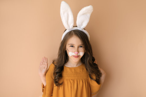 一个漂亮的女孩，一头卷发，戴着兔耳朵的发带，画着动物的妆容，双手高举，在镜头前看起来很可爱图片下载