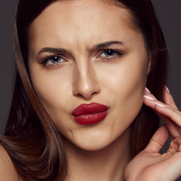 近距离的年轻美丽的黑发女孩的肖像，红唇摆出孤立的深灰色背景。美、时尚和美容的概念图片下载